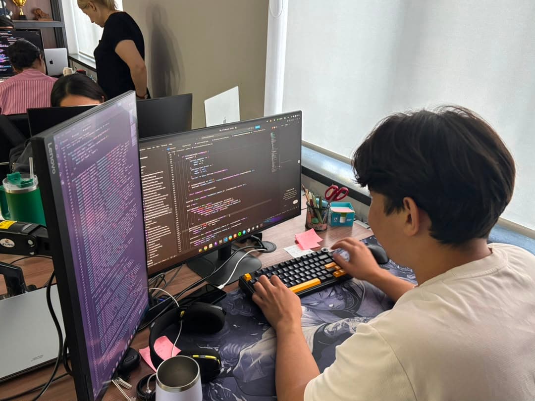 Developer writing code at a dual-monitor workstation
