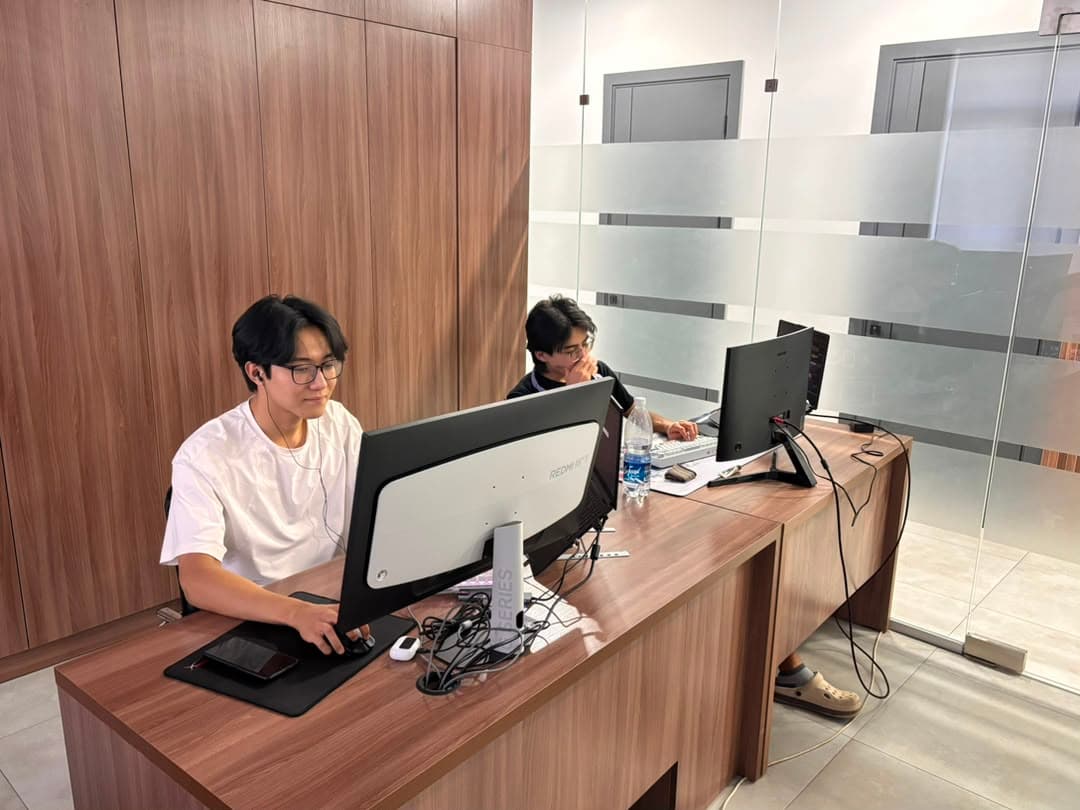 Developers at their desks by the glass partition