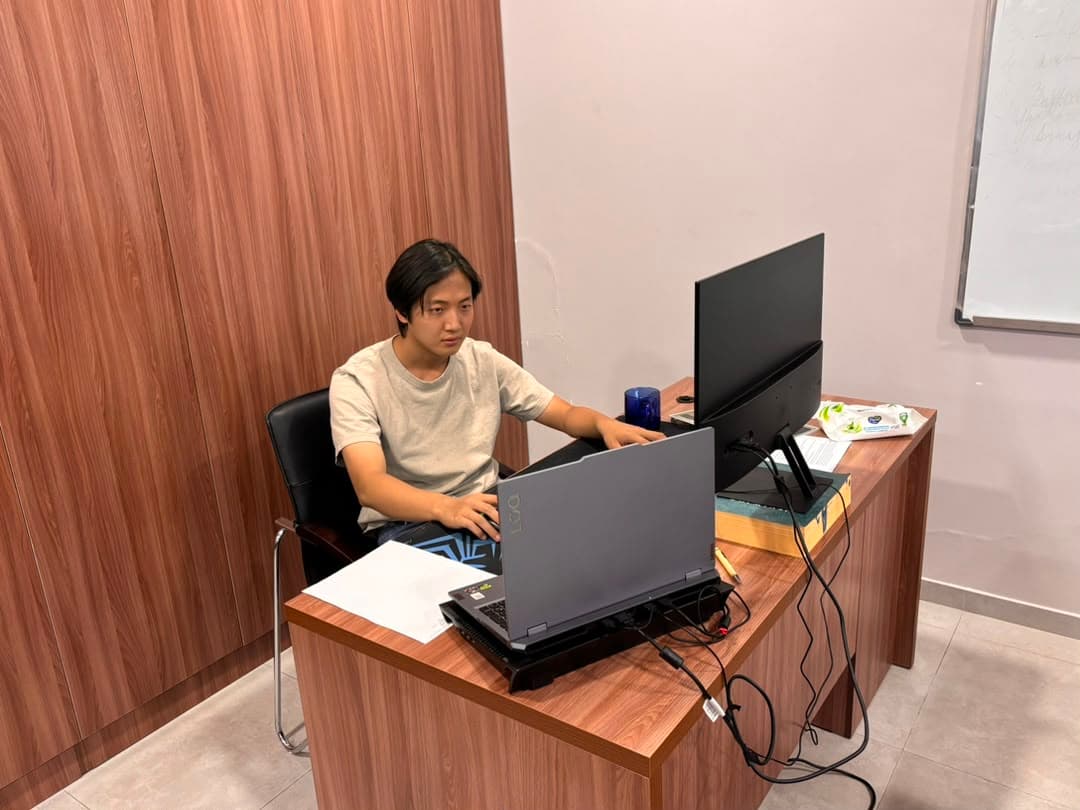 Developer at a workstation with a laptop and monitor